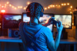 © Anton - Games online, a young girl playing computer games using a joystick or a gamepad. On three large monitors, creative light. Strategies, racing and gaming business