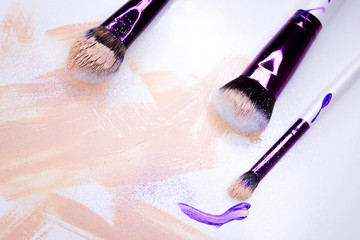 makeup brush and multicolored eyeshadow on white background