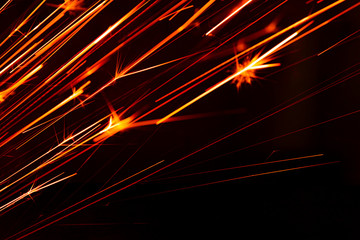 burning red hot sparks fly from large fire in the night sky. beautiful abstract background on the th