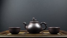 Ancient Teapot And Two Clay Bowls On A Wooden Surface With A Grey Background