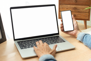 mockup image blank screen computer,cell phone with white background for advertising text,hand man using laptop texting mobile contact business search information on desk in cafe.marketing,design