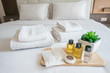 Set of hotel amenities (such as towels, shampoo, soap, gel etc) on the bed. Hotel amenities is something of a premium nature provided in addition to the room when renting a room.