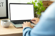© panitan - mockup image blank screen computer with blank white background for advertising text,hand man using laptop contact business search information on desk at home office.marketing and creative design
