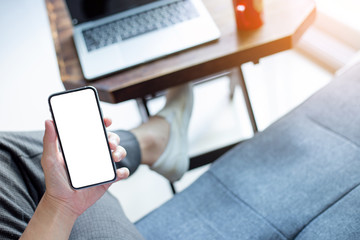 Mockup image blank white screen cell phone.man hand holding texting using mobile on desk at home office.background empty space for advertise text.people contact marketing business,technology