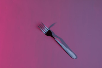 One steel fork. Neon pink blue night light