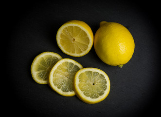 Primer plano de un conjunto de limones sobre una bandeja negra de piedra