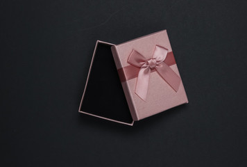 Wall Mural - Open Gift box with bow on black background. Composition for christmas, birthday or wedding. Top view