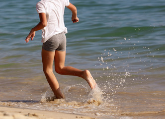 A boy runs on the water on the seashore