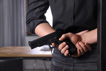 Man Holding Gun Indoors, Closeup. Dangerous Criminal