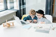 © pressmaster - Cute school friends with digital tablet scrolling through online information