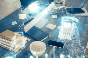 Desktop computer background in office and flying envelops hologram drawing. Multi exposure. Electronic mail concept.