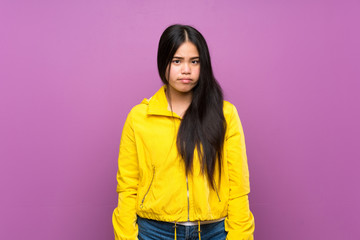 Young teenager Asian girl over isolated purple background with sad and depressed expression