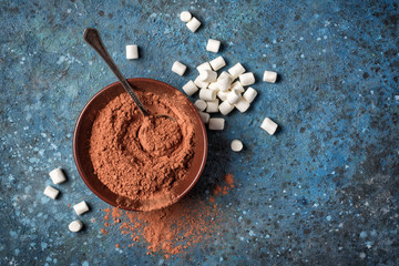 Wall Mural - Cocoa powder in brown bowl with silver spoon and white marshmallow