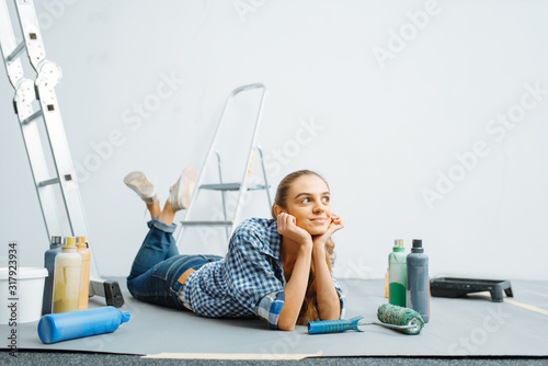 Fotomural Cheerful female house painter lies on the floor