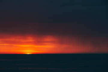 Wall Mural - Natural Colorful Sunset Sunrise Sky Over Sea After Storm Rain. Seascape With Shining Setting Sun On Sea Horizon