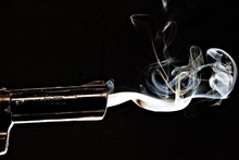 Closeup Shot Of A Smoking Gun With S Black Background