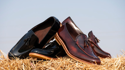 Men fashion tassel loafer shoes with black and brown polished leather on the straw.