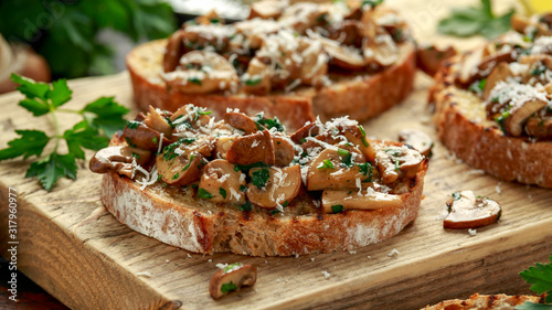 Fotografía Grilled mushroom toast with parsley, lemon and parmesan cheese on wooden board