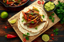 Beef Steak Fajitas With Tortilla Mix Pepper, Onion And Avocado On Wooden Board