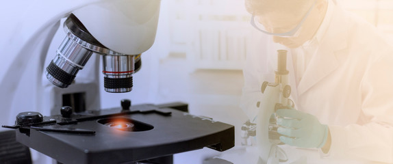 Wall Mural - laboratory concept; closed up picture of a microscope with a blurred background of scientist researc