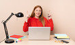 © luismolinero - Young student woman in a workplace with a laptop pointing up a great idea