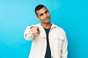 Young African American man over isolated blue background points finger at you with a confident expression