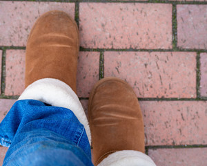 brown sheepskin boots and jeans on the pavement 