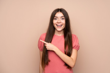 Wall Mural - Young woman over isolated background pointing finger to the side