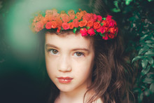 Close-Up Portrait Of Cute Girl Wearing Red Flowers