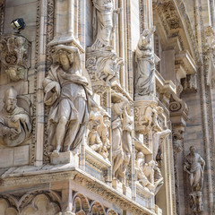 Wall Mural - Milan Cathedral (Duomo di Milano) close-up, Milan, Italy. Detail of luxury facade with many marble statues and reliefs. Milan Cathedral is top landmark of city.