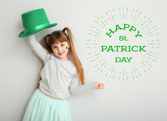 Wall Mural - Funny little girl and text HAPPY ST. PATRICK'S DAY on white background