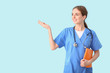 © Pixel-Shot - Female medical student showing something on color background
