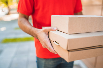 Delivery man carrying packages while making home delivery.