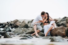 Couple Kissing At Beach Against Sky