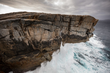 Dramatic early morning light and crashing waves at the Gap rock formation in Torndirrup National Park, Albany, Western Australia