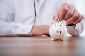 businessman hand putting coins with piggy bank.money saving and investment concept.