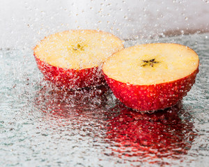 two apple slices in a spray of water