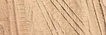 Panoramic Image. Tire Tracks On The Sand. Sand Texture