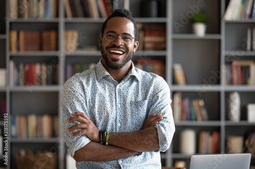 Fotomural Cheerful confident african young businessman standing at home office, portrait