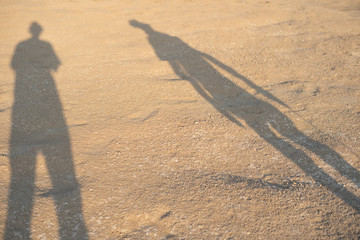 Wall Mural - The shadow of two people in the sand The background is sandy beach with sunshine