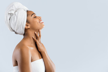 Joyful woman wrapped in towels looking at copy space