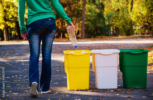 Fotografía Volunteer girl sorts garbage in the street of the park
