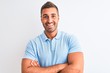 © Krakenimages.com - Young handsome elegant man wearing blue t-shirt over isolated background happy face smiling with crossed arms looking at the camera. Positive person.