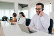 © bnenin - Cheerful businessman with headset working on computer and talking with a customer, portrait, copy space.