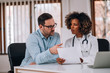 © bnenin - Patient talking to a doctor about test results at medical clinic office.