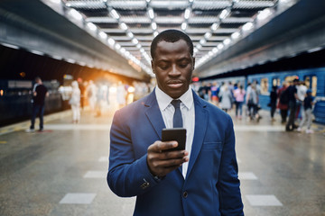 Businessman with smart phone on subway station