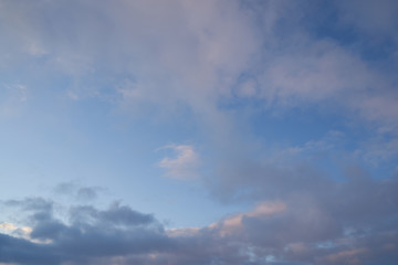 Beautiful evening blue sky at sunset with flaming bright light clouds