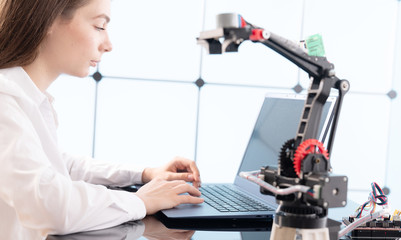 Canvas Print - Woman student with robot model arm