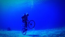 UNDERWATER VIEW OF SCUBA DIVER ON A BICYCLE