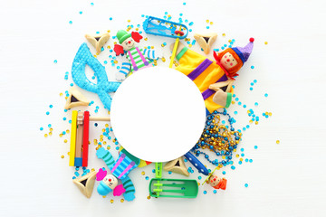 Purim celebration concept (jewish carnival holiday) over white wooden background. Top view, Flat lay